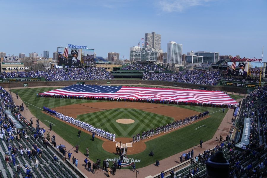 An American flag is unfurled in the outfield before at Wrigley Field before the opening day baseball game between the Chicago Cubs and Milwaukee Brewers, Thursday, March 30, 2023, in Chicago. (AP Photo/Erin Hooley)