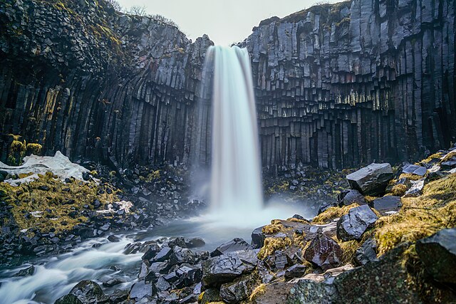 Svartifoss waterfall in Iceland photographed with long exposure. The waterfall is surrounded by natural basalt hexagonal columns. Photo by Giles Laurent, Wikimedia Commons