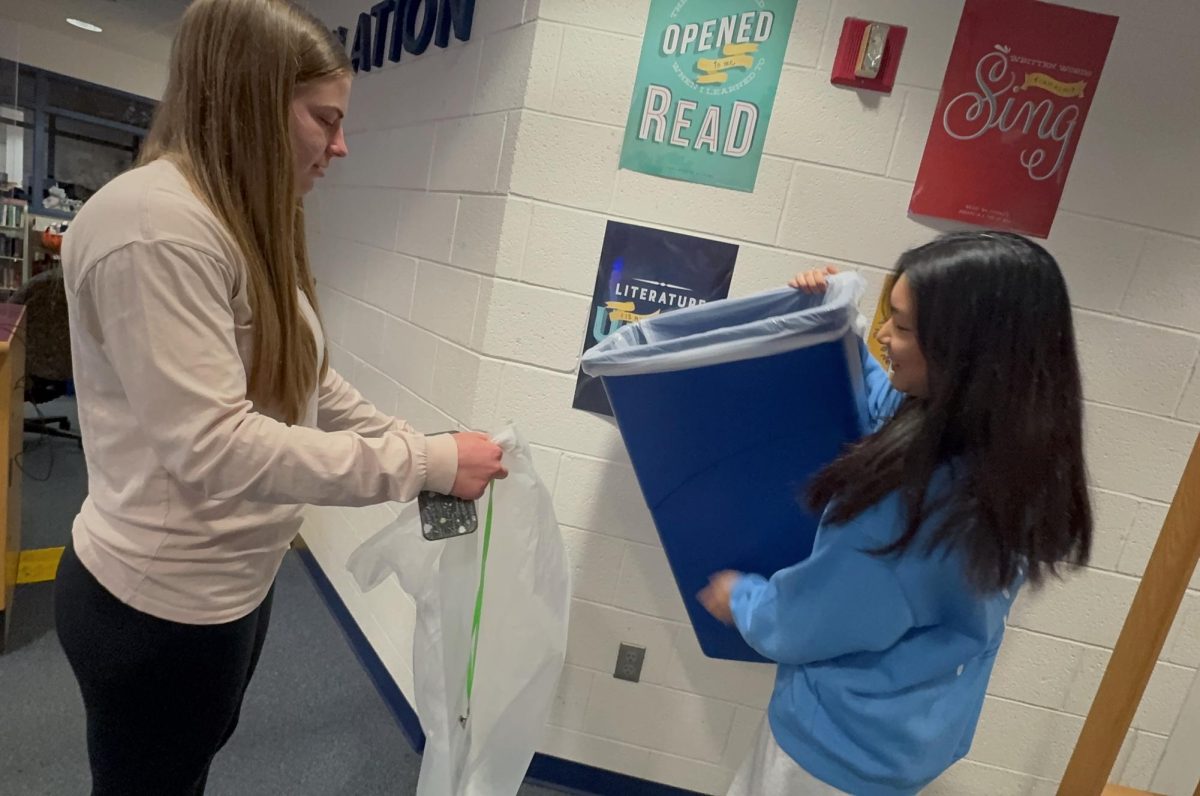 Lina Kong and Kayleigh Haes recycling materials at the library. 